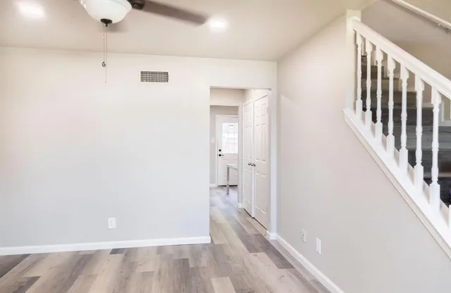 a view of a hallway with wooden floor and staircase