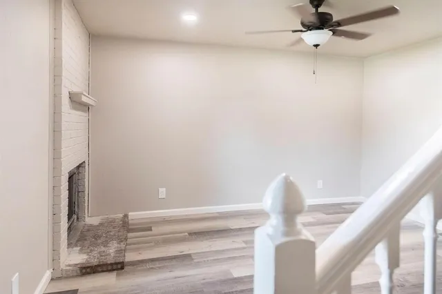 a view of an empty room with a window and a fireplace