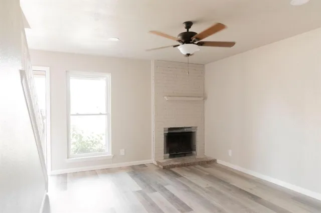 a view of a hallway with wooden floor and a window