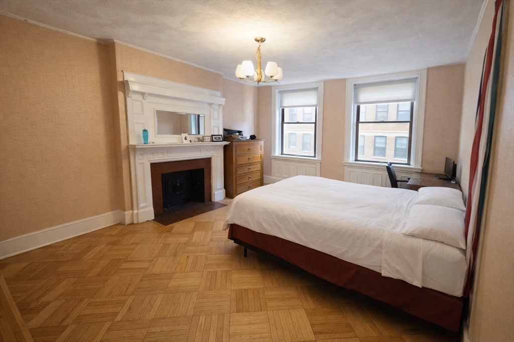 30 Claflin Road, Unit 2 Brookline, MA 02445 - Photo 8 of 10 a bedroom with a large bed and a fireplace