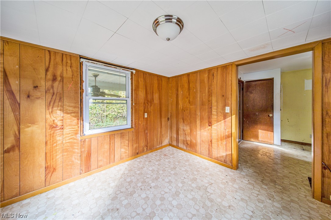 1168 Garrison Road Ashtabula, OH 44004 - Photo 31 of 35 Empty room featuring wood walls and light tile floors