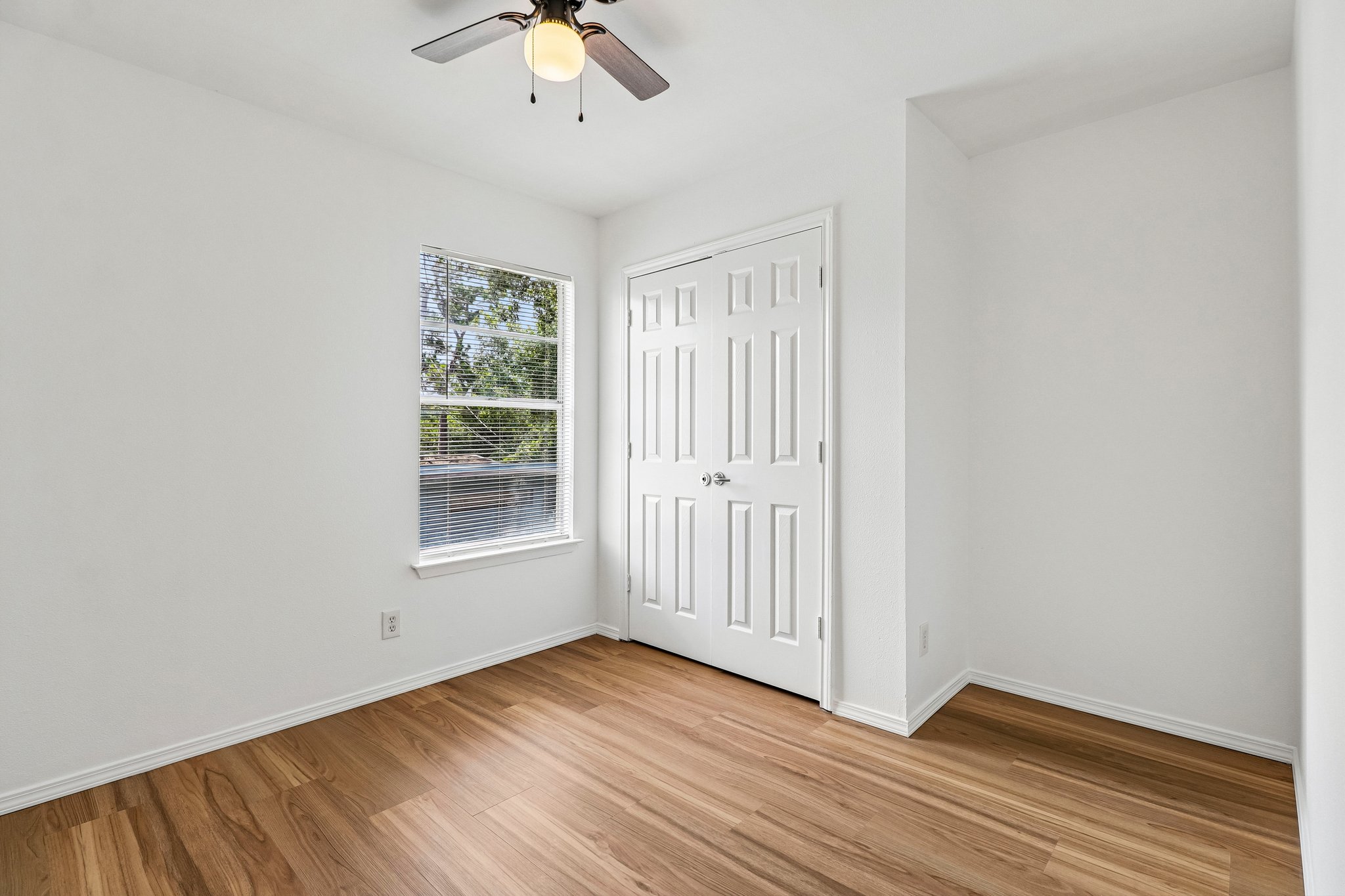 5809 Coventry Lane Austin, TX 78723 - Photo 17 of 35 Warm wood-look flooring complements bright walls, leading to a closet with double panel doors.
