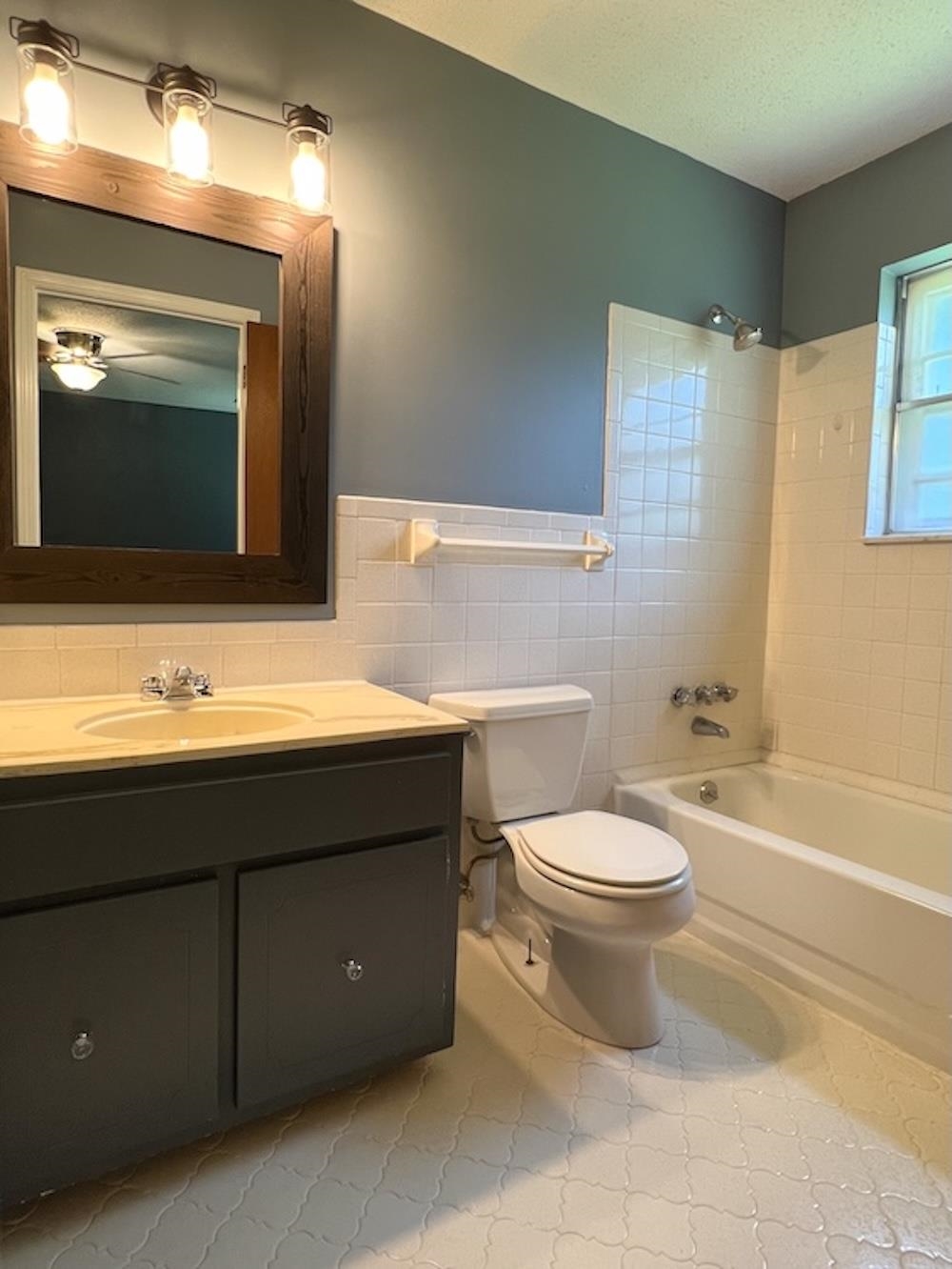 7935 Memphis Arlington Road Bartlett, TN 38133 - Photo 15 of 20 Full bathroom featuring a single vanity with a solid surface countertop, wood-framed mirror, and a three-light fixture