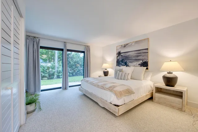 a bedroom with a bed and large window