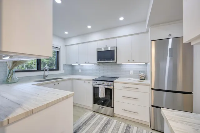 a kitchen with a refrigerator stove and sink