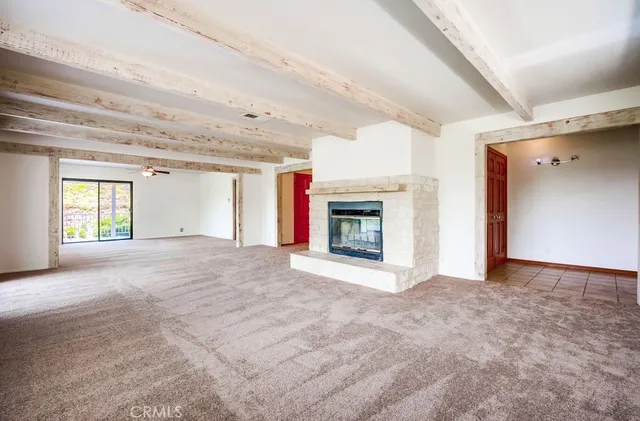 a view of empty room with fireplace and windows