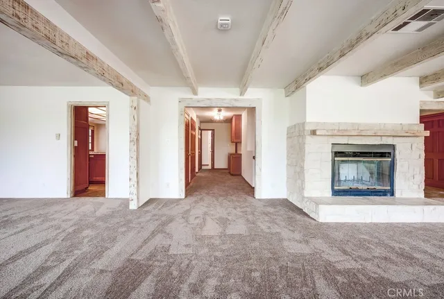 a view of an empty room with window chandelier fan