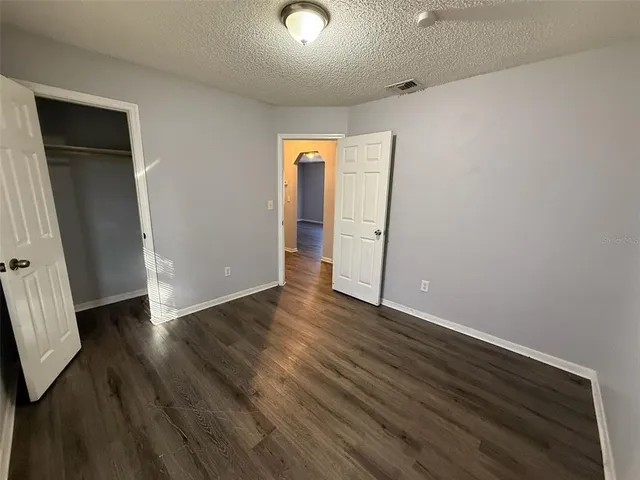 an empty room with wooden floor and closet