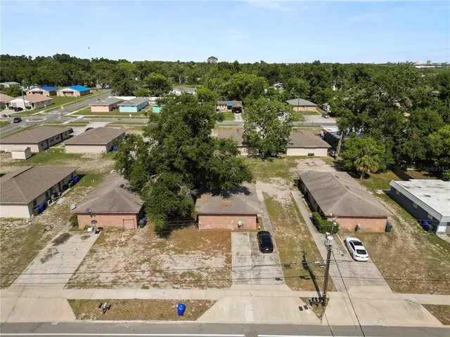 an aerial view of residential houses with outdoor space and trees
