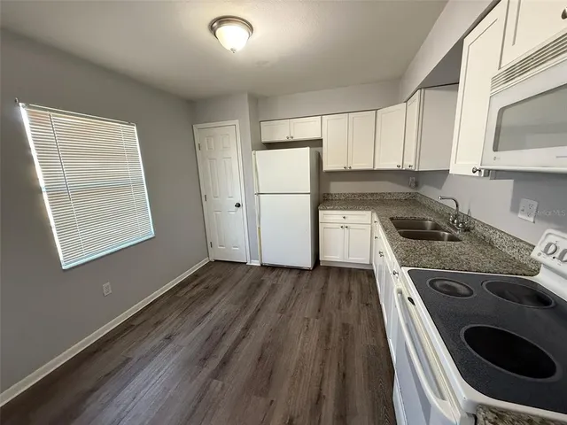 a kitchen with kitchen island wooden floors and stainless steel appliances