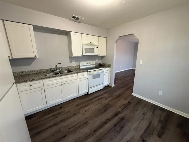 a kitchen with a sink stove and cabinets
