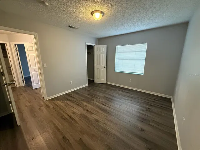 an empty room with wooden floor and a window