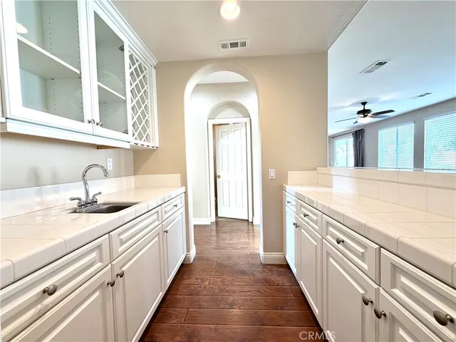 a view of a kitchen with kitchen island a stove a wooden floor and a chandelier