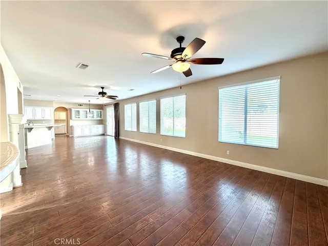 a large kitchen with a lot of counter space and wooden floor