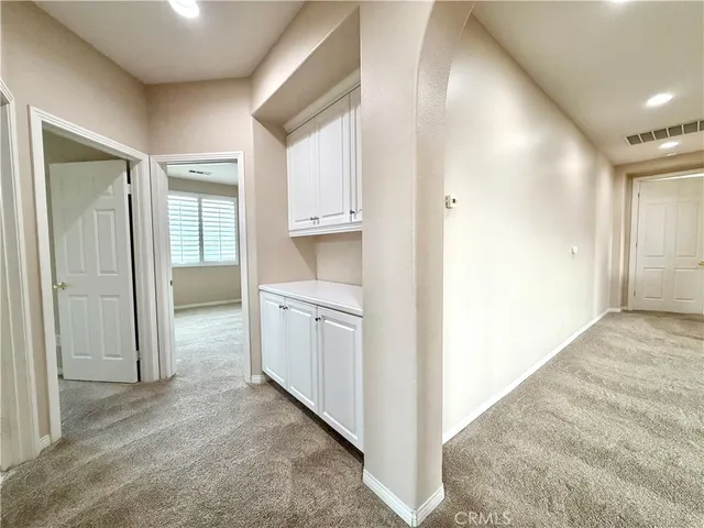 an empty room with windows and mirror