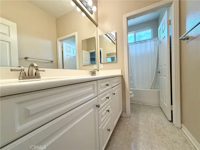 a bathroom with a granite countertop sink mirror and a shower