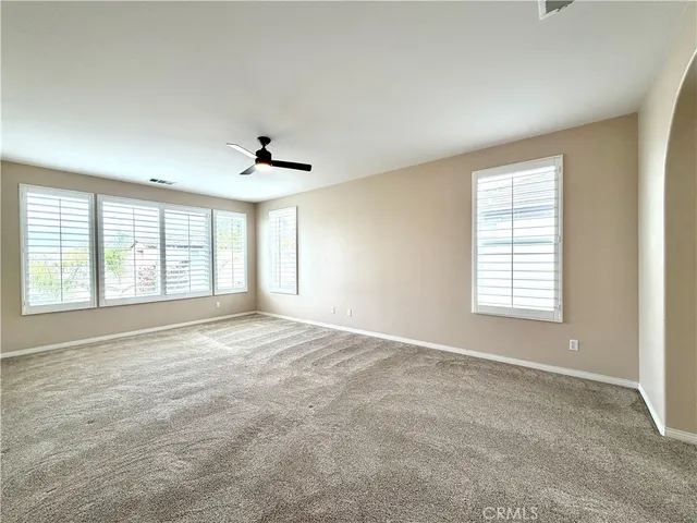 a view of a white house with a big yard and garden