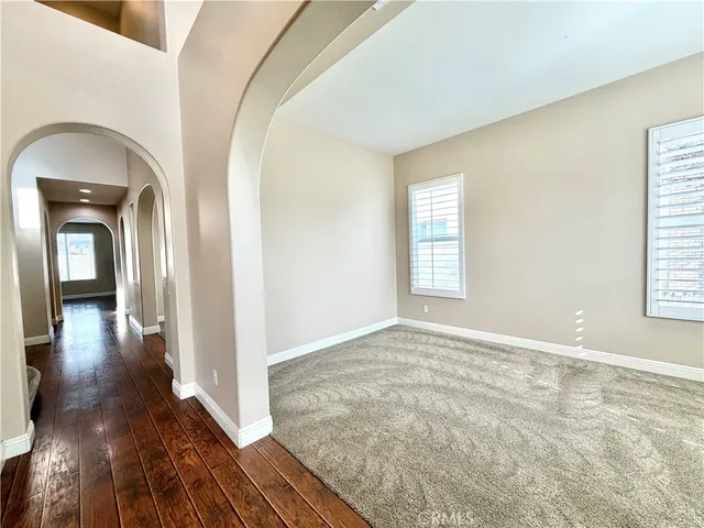 a view of a hallway with wooden floor and a living room