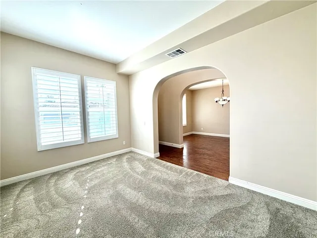 an empty room with window and mirror