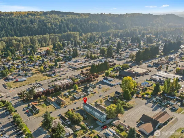 an aerial view of residential house with parking and trees