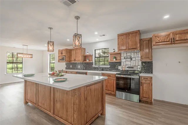 a kitchen with stainless steel appliances granite countertop a sink stove and refrigerator