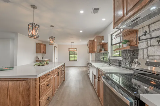 a kitchen with stainless steel appliances granite countertop a lot of counter space and a sink