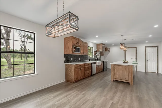 a large kitchen with a lot of counter space and wooden floor