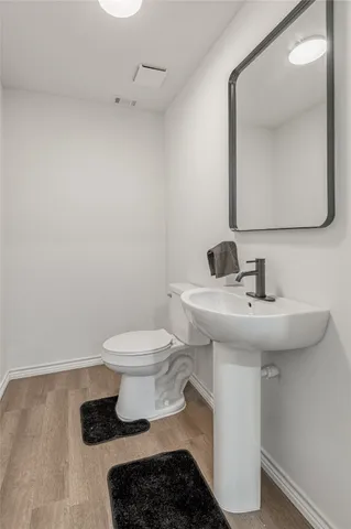 a bathroom with a sink toilet and mirror