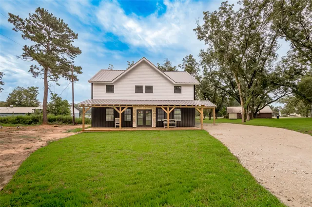 a view of a house with a yard and tree s