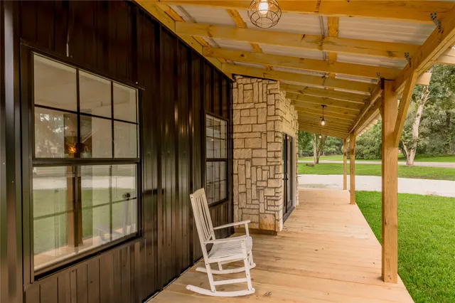 a view of a porch with wooden floor and iron stairs