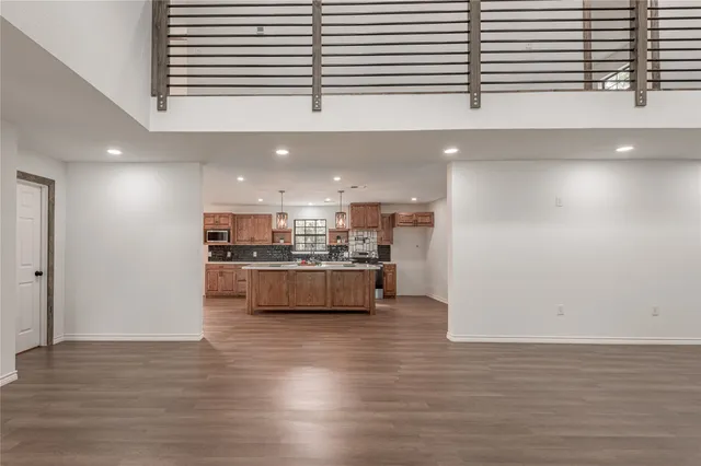 a room with stainless steel appliances kitchen island granite countertop a stove a sink and a refrigerator