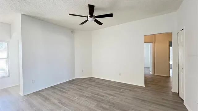 a view of a room with wooden floor and a ceiling fan
