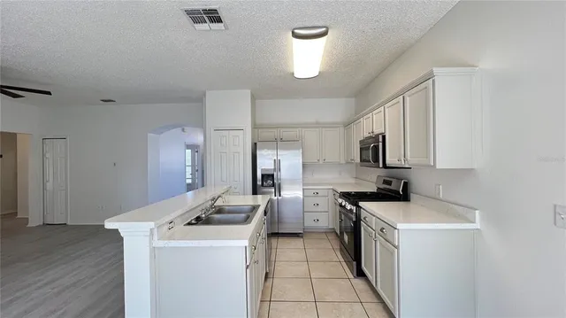 a kitchen with a sink a stove top oven and wooden floor