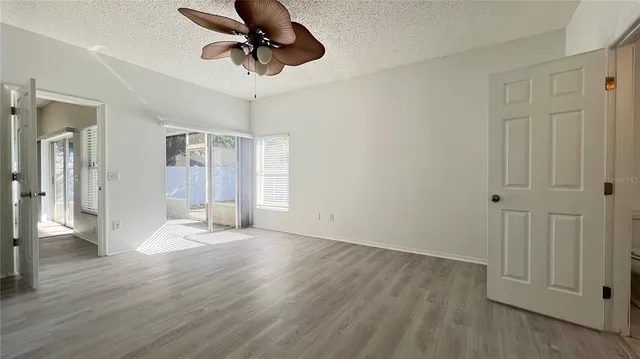a view of a livingroom with wooden floor and a ceiling fan