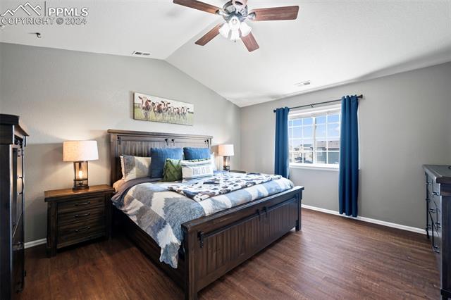 6382 Pilgrimage Road Colorado Springs, CO 80925 - Photo 17 of 32 Primary Bedroom with ceiling fan, vaulted ceiling, and dark hardwood / wood-style floors