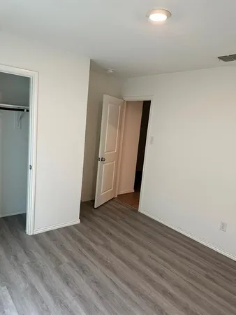 an empty room with wooden floor and closet