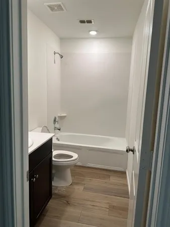 a bathroom with a bathtub shower sink vanity and toilet
