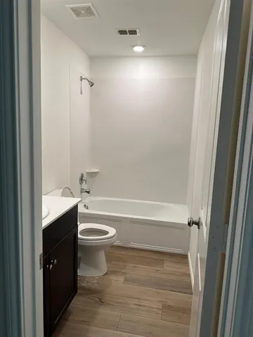 a bathroom with a bathtub shower sink vanity and toilet