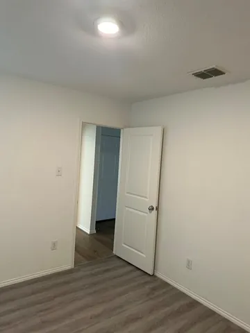 an empty room with wooden floor and closet