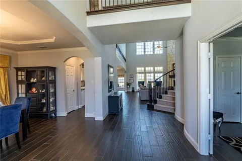 a view of a hallway with wooden floor and a living room