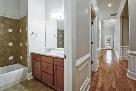 a bathroom with a tub shower vanity and a sink