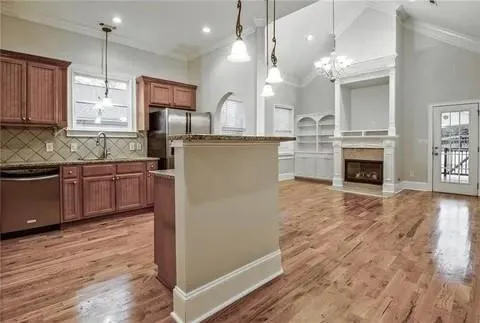 a kitchen with kitchen island a counter top space a sink stainless steel appliances and cabinets