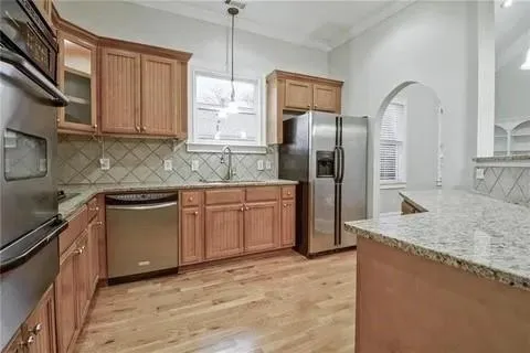 a kitchen with stainless steel appliances granite countertop a refrigerator a sink and a stove