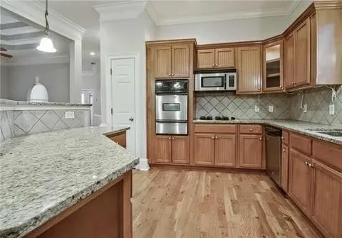 a kitchen with stainless steel appliances granite countertop a stove and cabinets