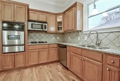 a kitchen with stainless steel appliances granite countertop a sink a stove and microwave