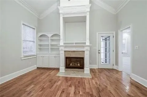 a view of a livingroom with a fireplace wooden floor and window