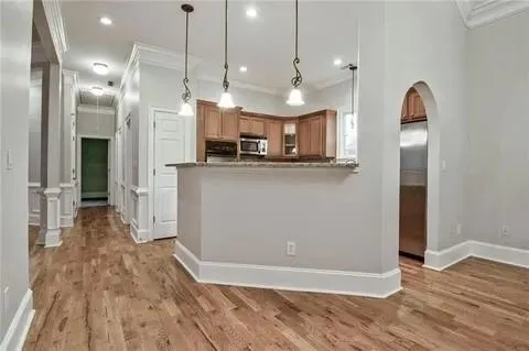 a view of a kitchen with a refrigerator a sink and wooden floor