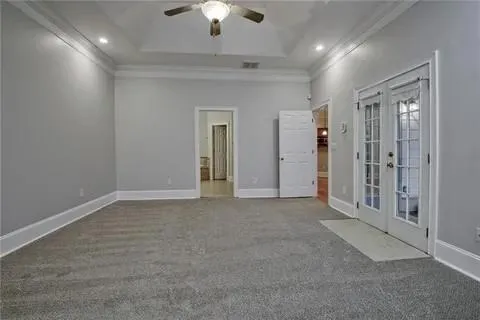 en empty room with windows and chandelier fan