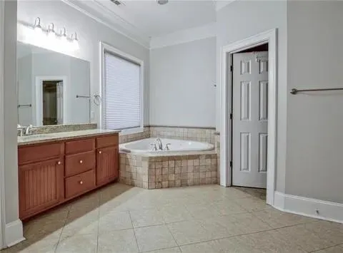 a spacious bathroom with a granite countertop tub sink and mirror