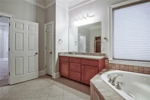 a bathroom with a tub sink and mirror